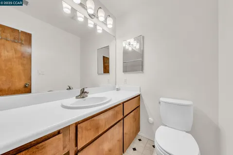 a bathroom with a toilet a sink and mirror
