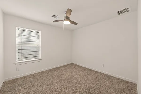 an empty room with windows and fan