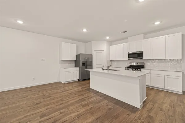 a kitchen with stainless steel appliances a refrigerator sink and microwave