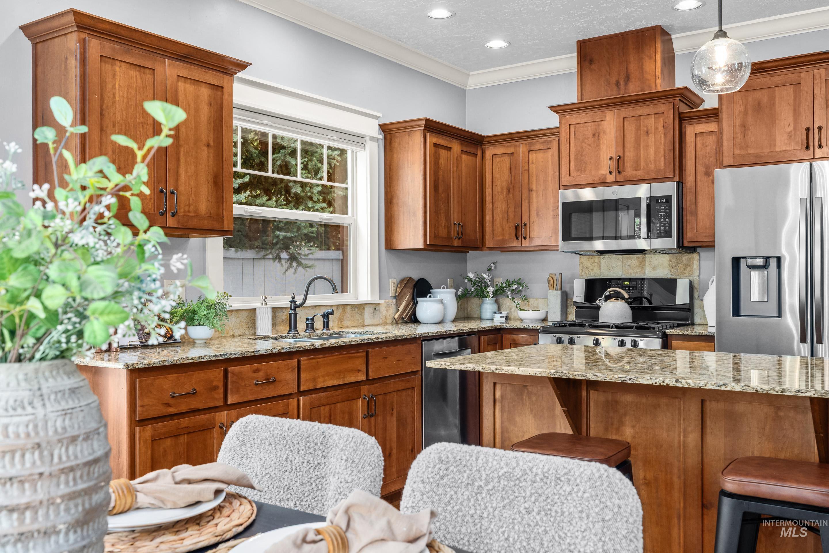 1862 West Ridenbaugh Street Boise, ID 83702 - Photo 22 of 40 Kitchen featuring wood cabinetry, light-toned countertops, stainless steel appliances, and a central island