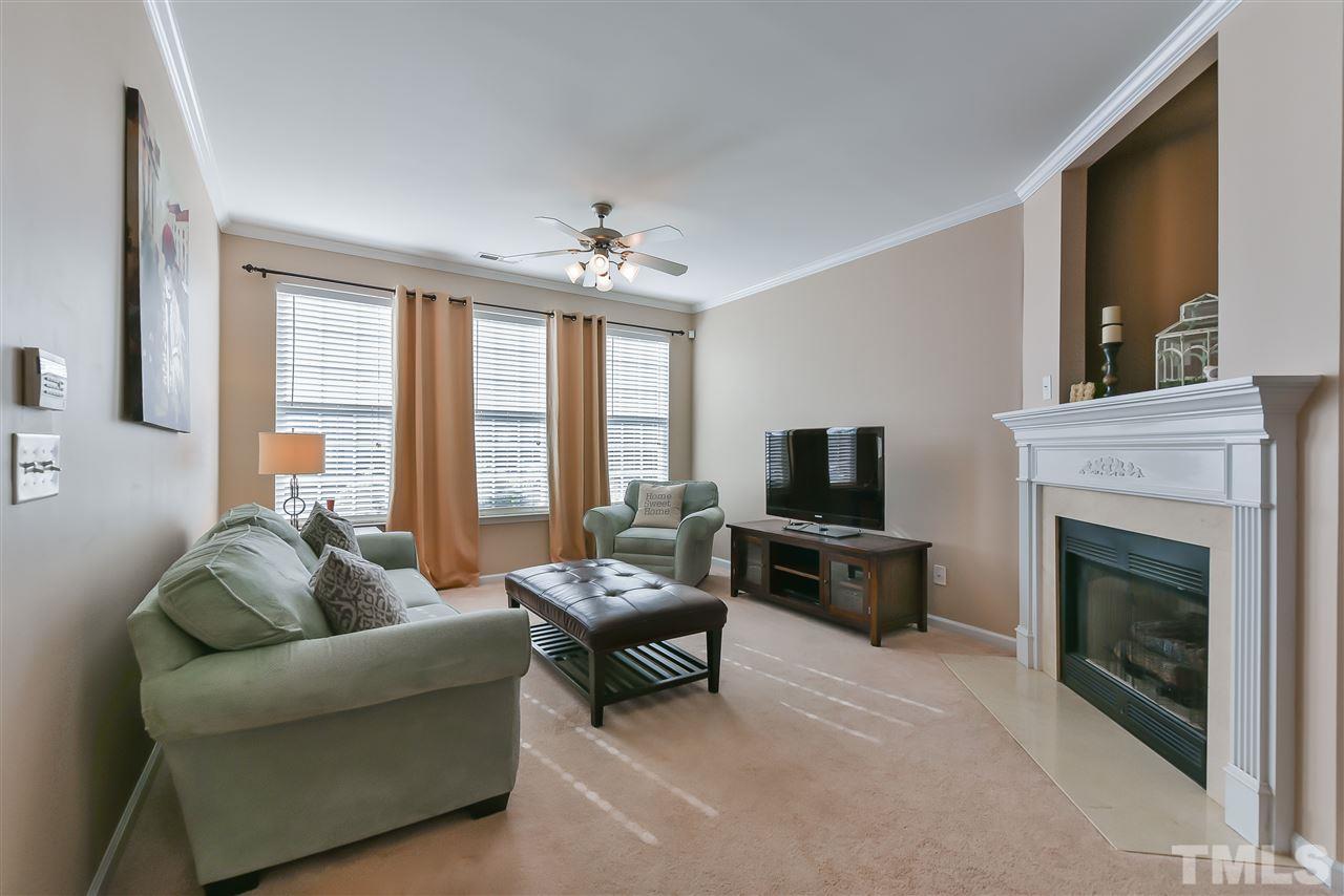 8240 City Loft Court Raleigh, NC 27613 - Photo 2 of 5 a living room with furniture flat screen tv and a fireplace