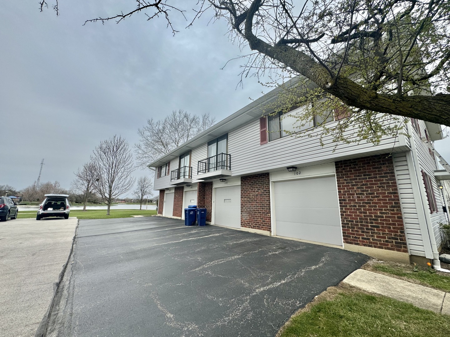102 North Salem Drive, Unit 102 Schaumburg, IL 60193 - Photo 1 of 19 a view of a white house with large trees and playing area