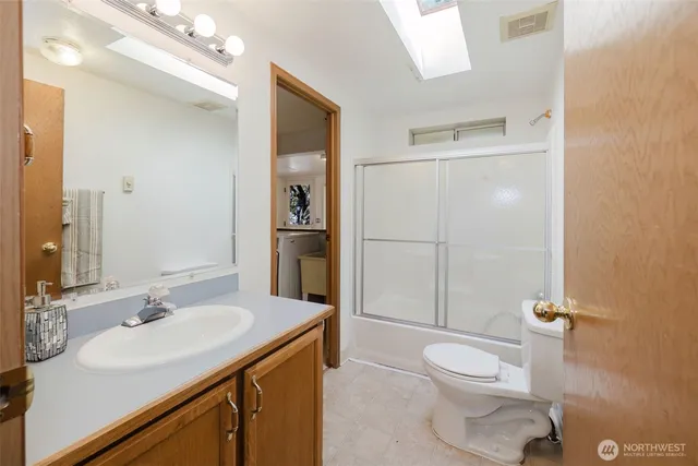 a bathroom with a sink toilet vanity and shower