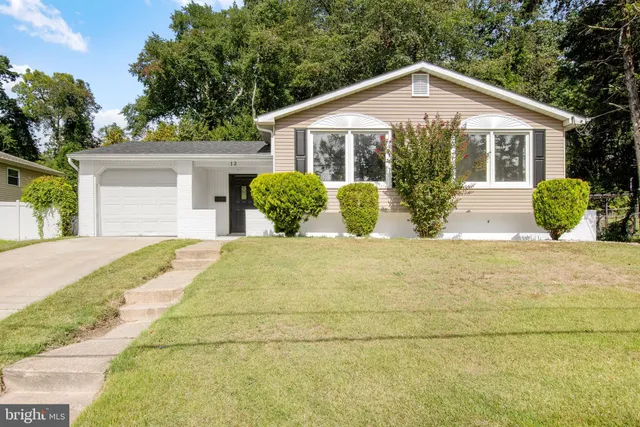 a front view of a house with a garden and plants