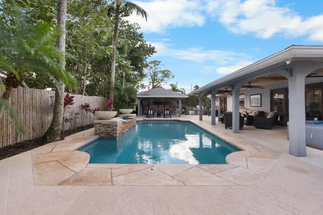 a view of a house with swimming pool and sitting area
