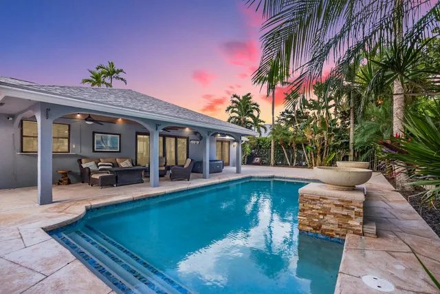 a view of house with swimming pool and sitting area
