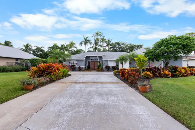 a view of a house with a yard and potted plants