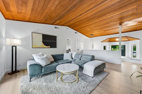 a living room with furniture a rug and a painting on the wall