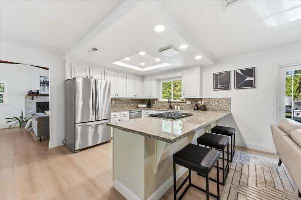 a kitchen with refrigerator and chairs