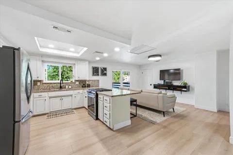 a kitchen with stainless steel appliances a stove a sink and a refrigerator