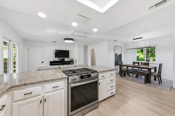 a kitchen with granite countertop cabinets stainless steel appliances and dining table