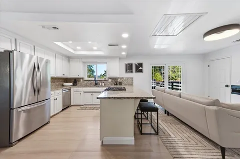 a kitchen with white cabinets and stainless steel appliances