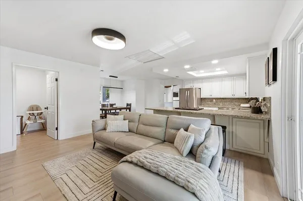 a living room with furniture and a view of kitchen
