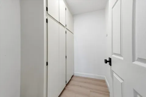 a view of a hallway with white walls and stairs