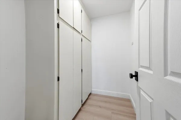 a view of a hallway with white walls and stairs