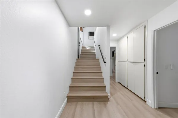 a view of a hallway with wooden floor and entryway