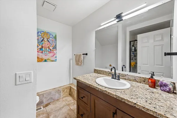 a bathroom with a granite countertop sink and a mirror