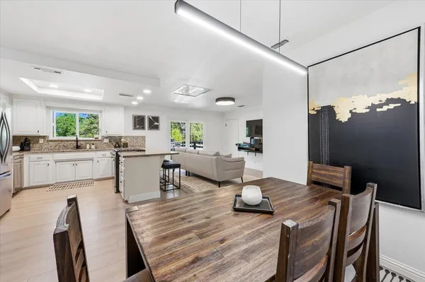 a open dining room with furniture and wooden floor