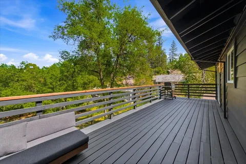 a view of backyard with a small deck and wooden floor