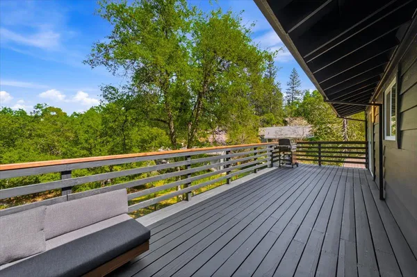 a view of backyard with a small deck and wooden floor