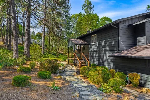 a side view of a house with a deck and a backyard