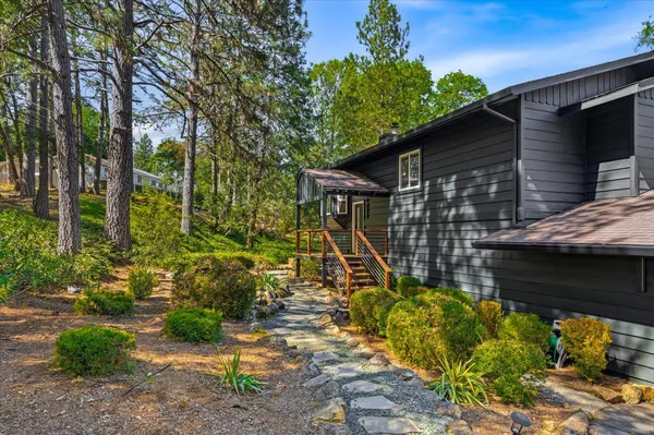 a side view of a house with a deck and a backyard