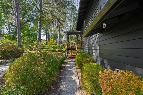 an aerial view of residential house with outdoor space and trees all around