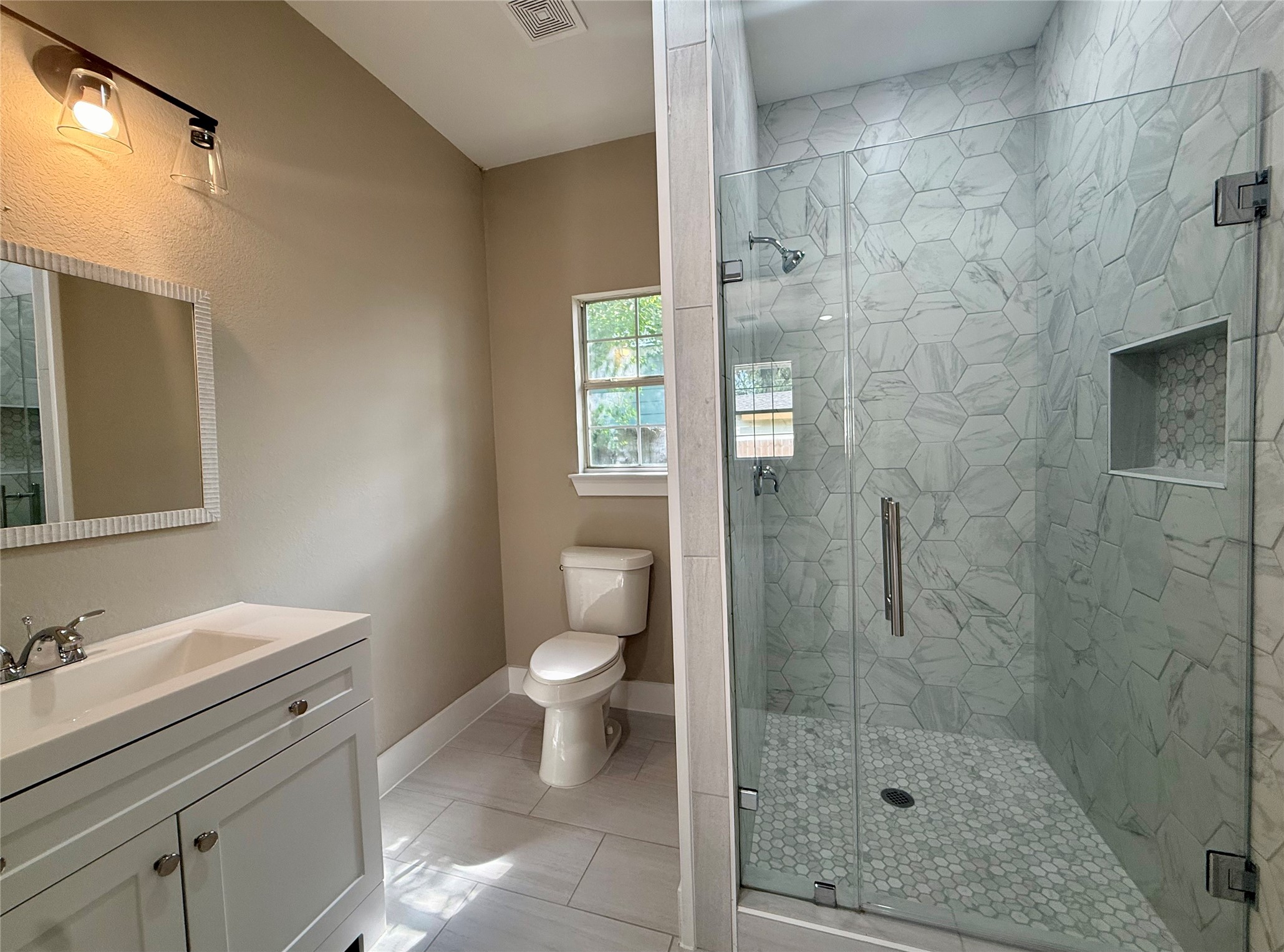 1816 Ryon Street Houston, TX 77009 - Photo 11 of 14 a bathroom with a granite countertop sink toilet a mirror and shower