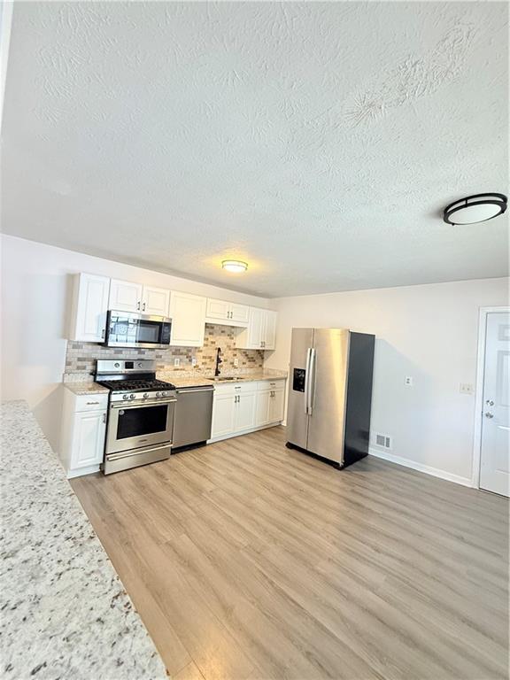 554 Fort Street Northeast Marietta, GA 30060 - Photo 7 of 15 a kitchen with stainless steel appliances granite countertop a stove top oven and sink