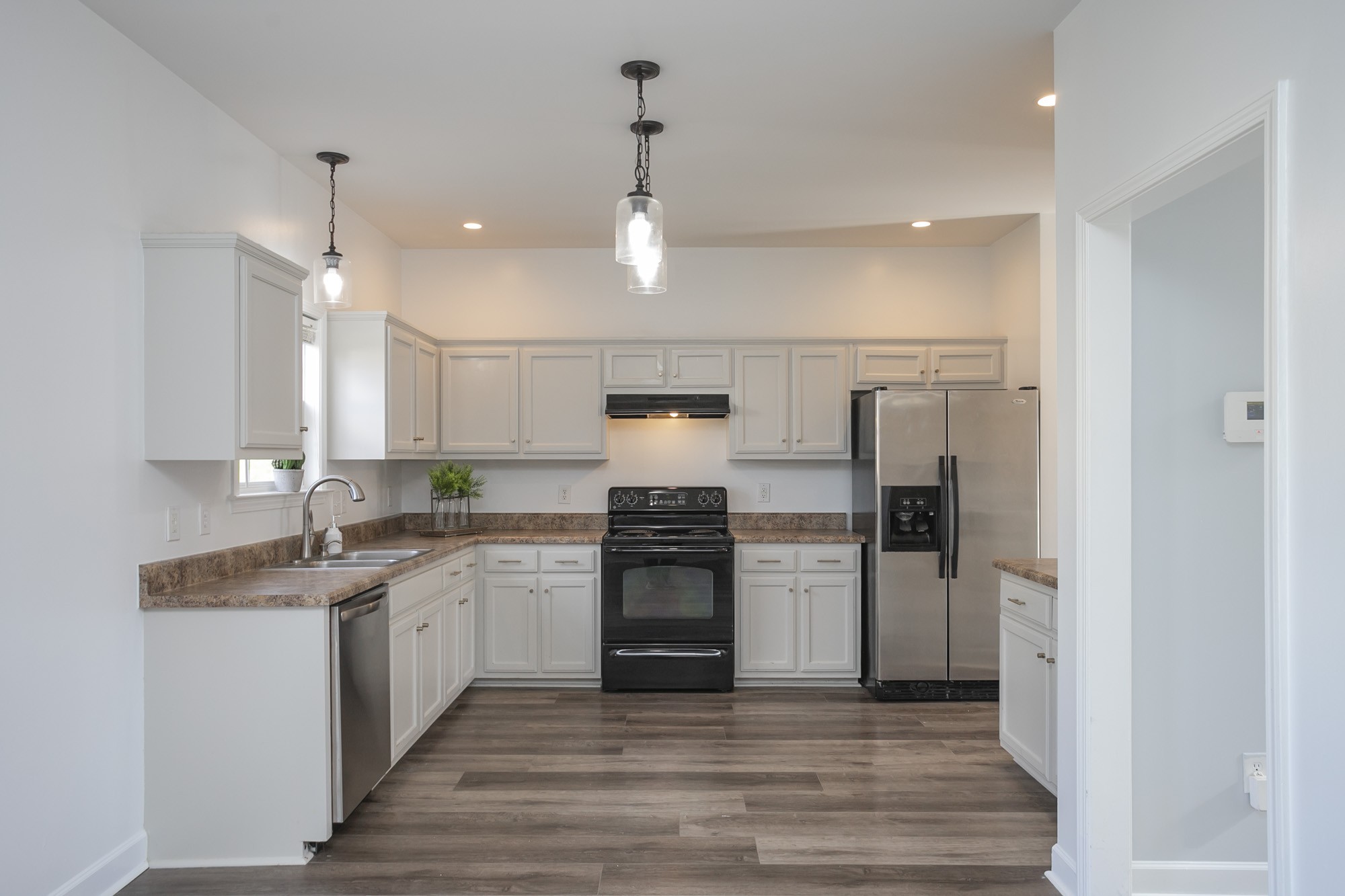 6004 Romain Court Spring Hill, TN 37174 - Photo 9 of 48 a kitchen with stainless steel appliances granite countertop a refrigerator a oven and white cabinets with wooden floors
