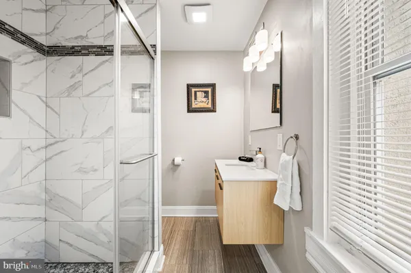 a bathroom with a sink a mirror and shower