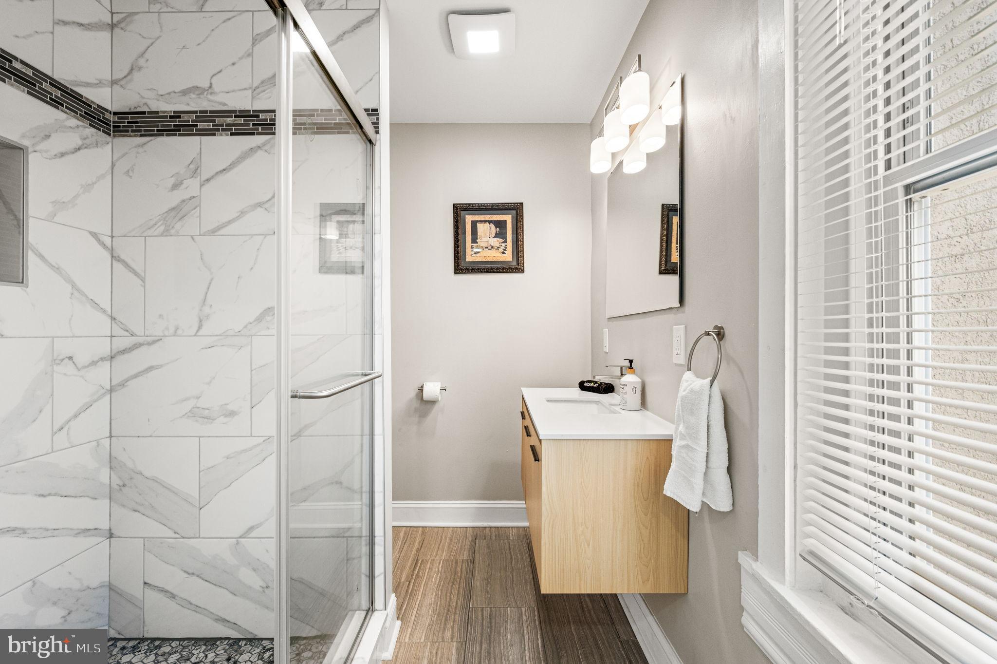 930 North 30th Street Philadelphia, PA 19130 - Photo 18 of 20 a bathroom with a sink a mirror and shower