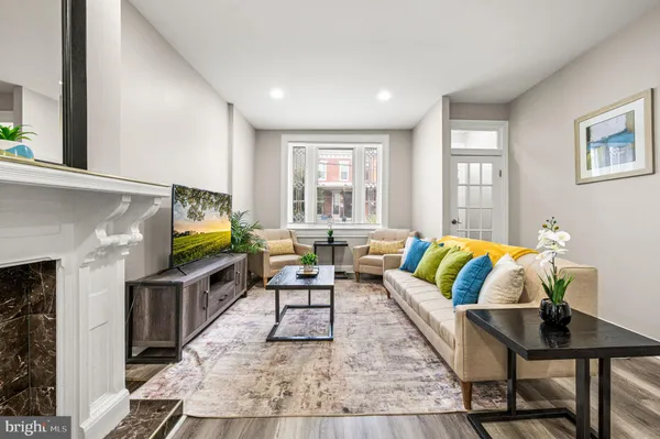 a living room with fireplace furniture flat screen tv and windows