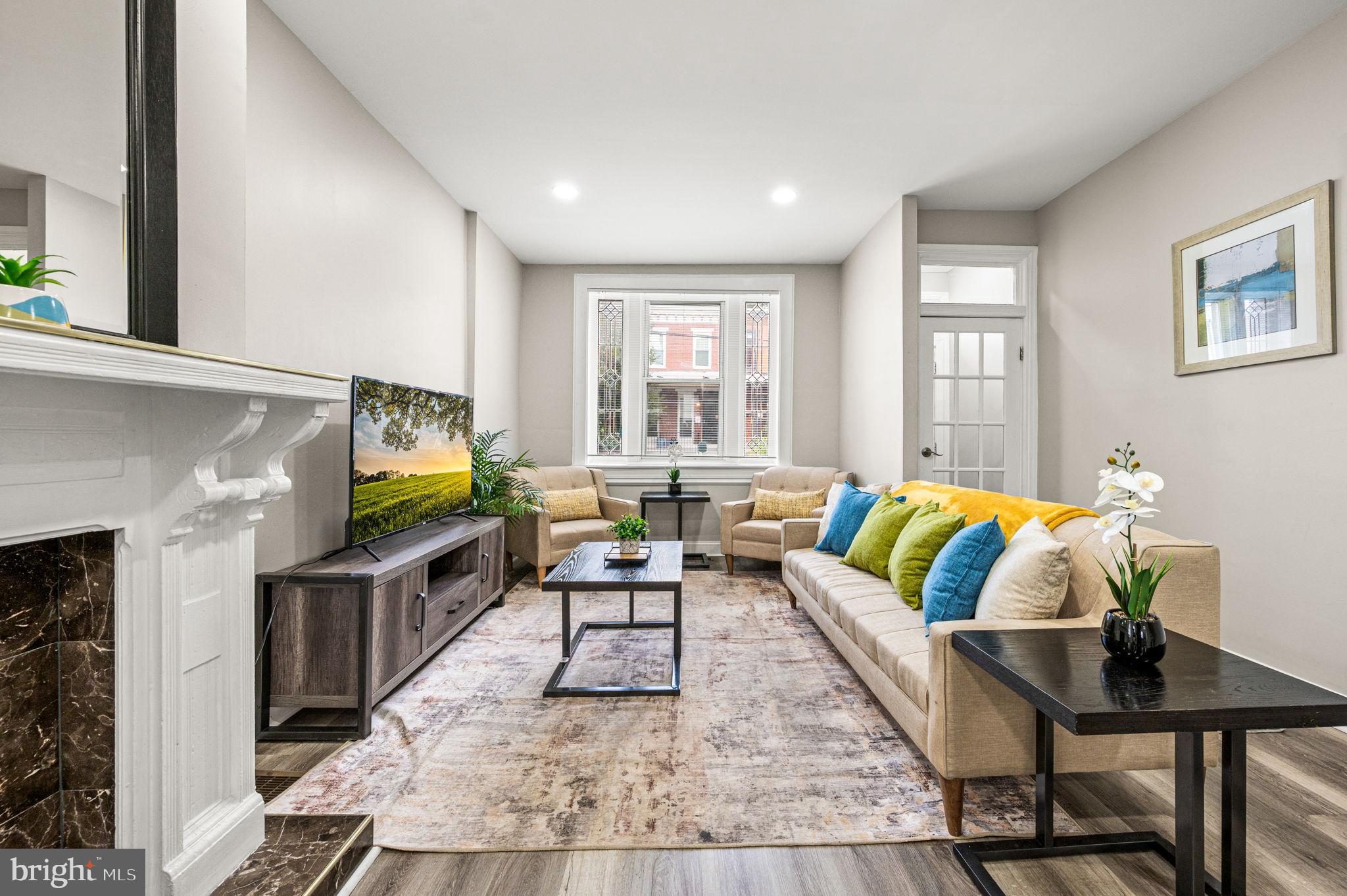 930 North 30th Street Philadelphia, PA 19130 - Photo 2 of 20 a living room with fireplace furniture flat screen tv and windows