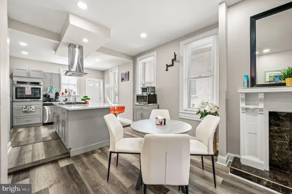 a kitchen with a dining table chairs and refrigerator