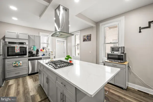 a kitchen with granite countertop stainless steel appliances a stove oven and a refrigerator