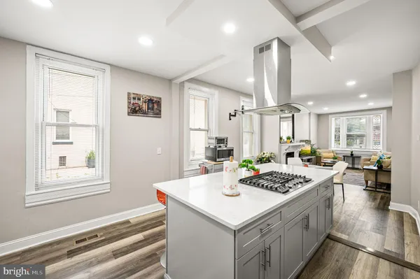 a kitchen with a stove a refrigerator a sink dishwasher with a dining table and chairs with wooden floor