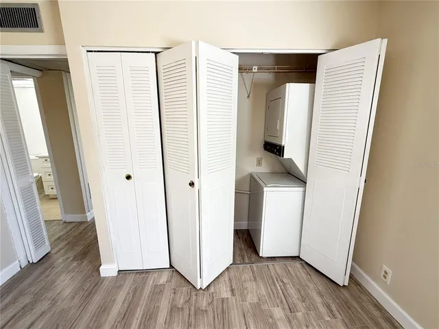 a view of a hallway with wooden floor and cabinets
