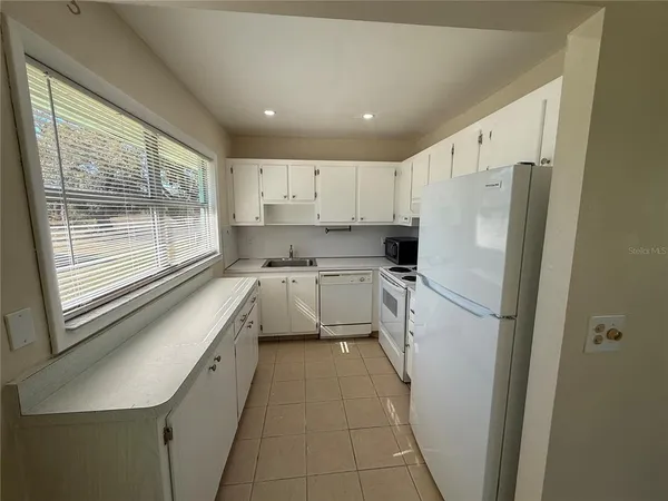 a kitchen with a refrigerator a sink and a stove top oven