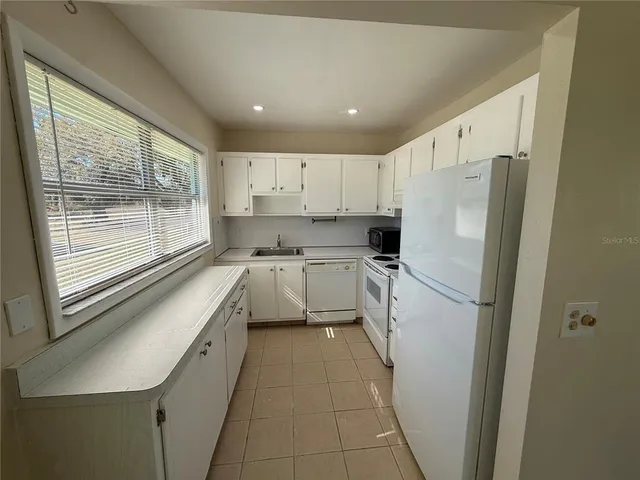 a kitchen with a refrigerator a sink and a stove top oven