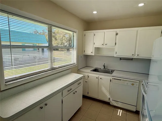 a kitchen with stainless steel appliances granite countertop a sink a stove and white cabinets