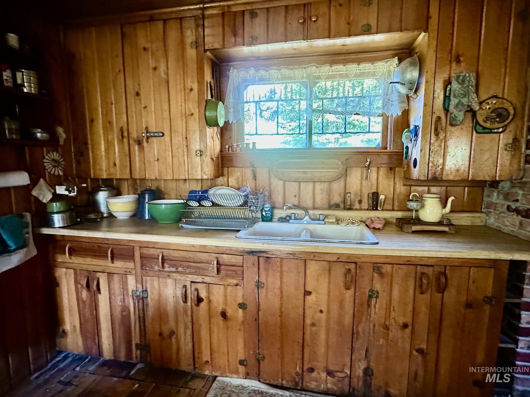 509 Deadline Road, Unit 2 Twin Falls, ID 83301 - Photo 14 of 28 Kitchen featuring extensive knotty pine cabinetry, a double basin sink, and wood-finish flooring