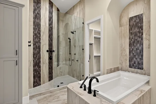 a bathroom with a tub sink and mirror