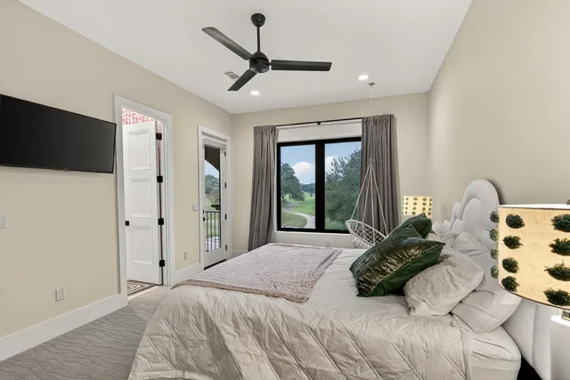 a bedroom with a bed mirror and a large window