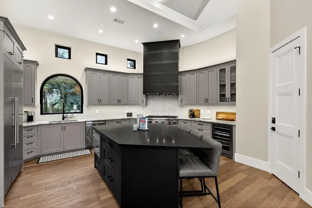 a kitchen with kitchen island granite countertop a table chairs sink and cabinets
