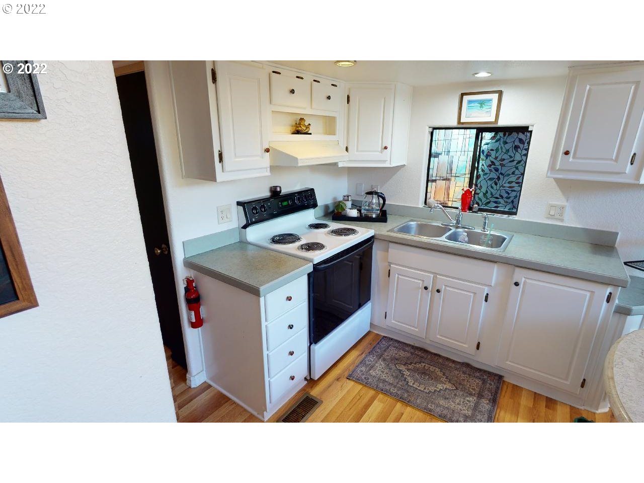 97748 North Bank Chetco River Road, Unit 11 Brookings, OR 97415 - Photo 18 of 32 a kitchen with a sink stove and cabinets