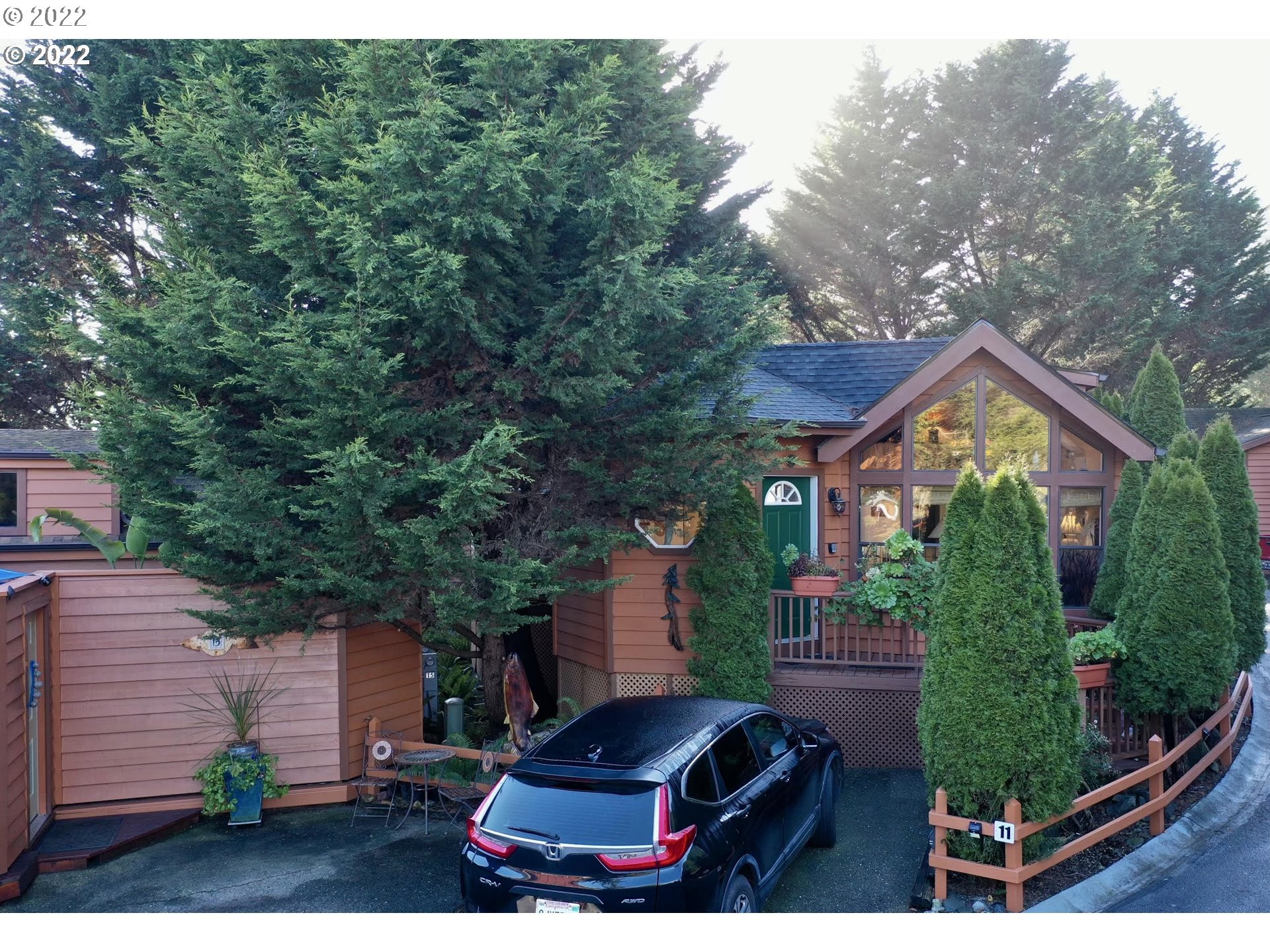 97748 North Bank Chetco River Road, Unit 11 Brookings, OR 97415 - Photo 2 of 32 a house view with a garden space