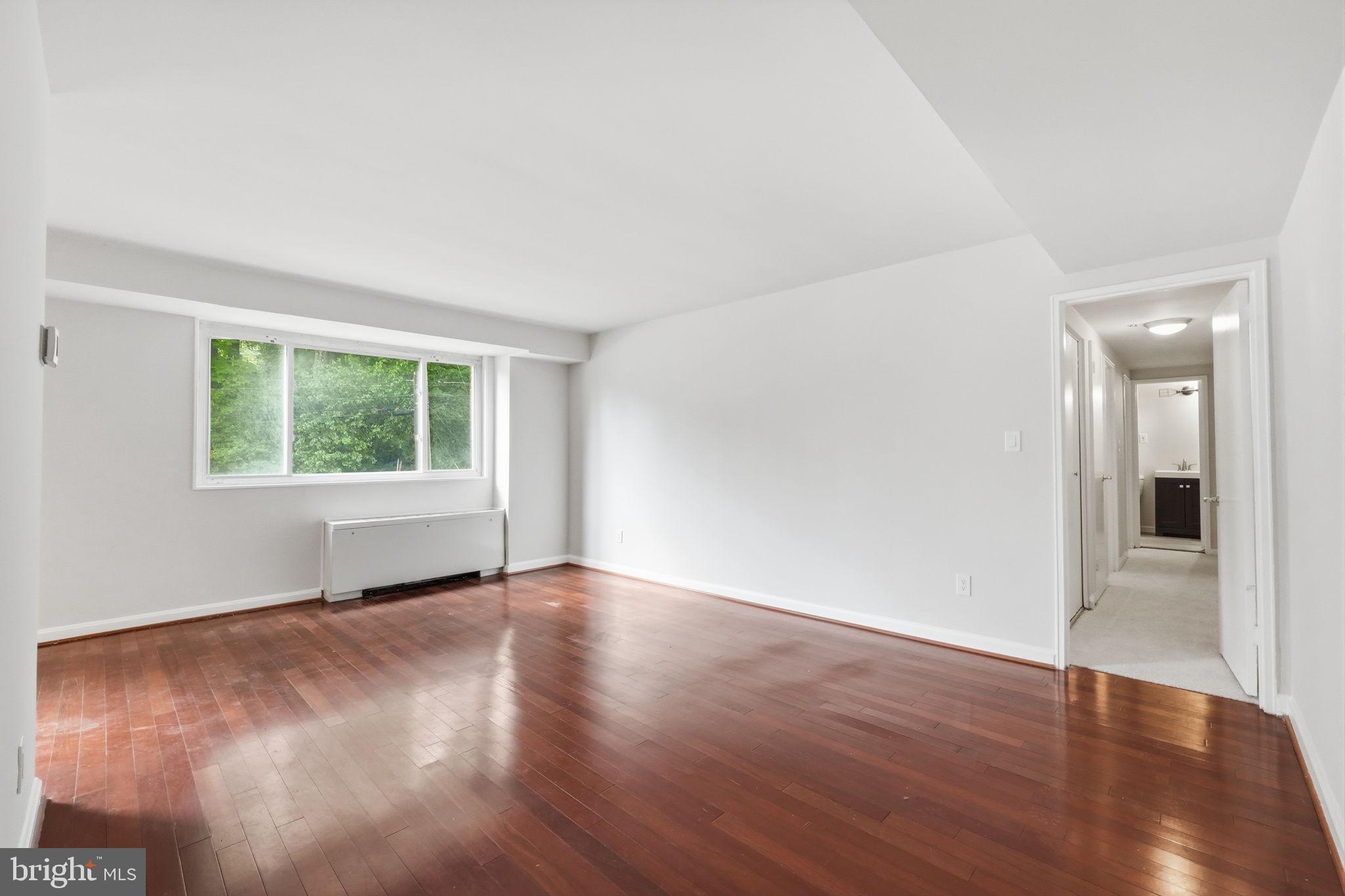 95 East Wayne Avenue, Unit 101 Silver Spring, MD 20901 - Photo 11 of 20 an empty room with wooden floor and windows