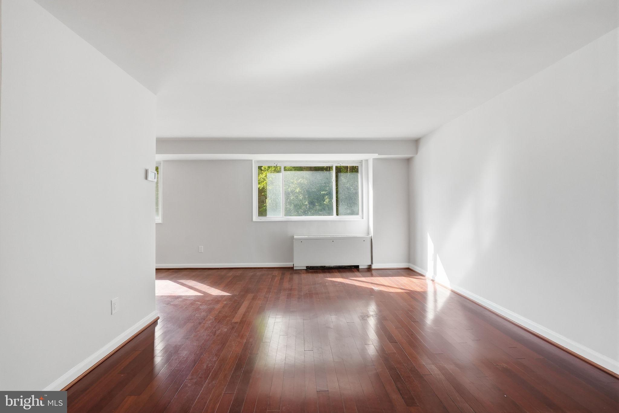 95 East Wayne Avenue, Unit 101 Silver Spring, MD 20901 - Photo 12 of 20 an empty room with wooden floor and windows