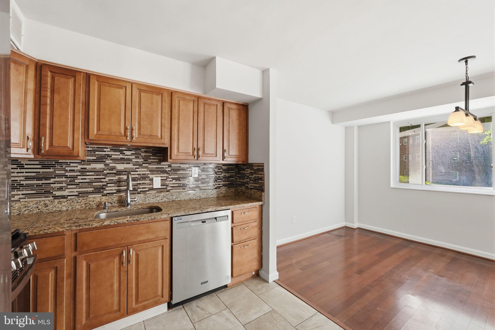 95 East Wayne Avenue, Unit 101 Silver Spring, MD 20901 - Photo 16 of 20 a kitchen with granite countertop a sink cabinets and window